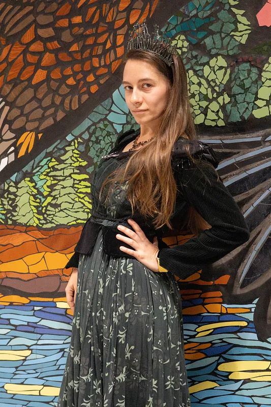 Plano medio de Forest usado por una modelo, mostrando el corpiño verde oscuro, la falda floral, la cintura negra y los detalles brillantes en hombros.