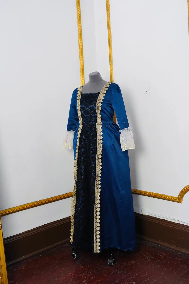 Vasilisa: vestido azul profundo con brocado oscuro y encajes, inspirado en los cuentos rusos.