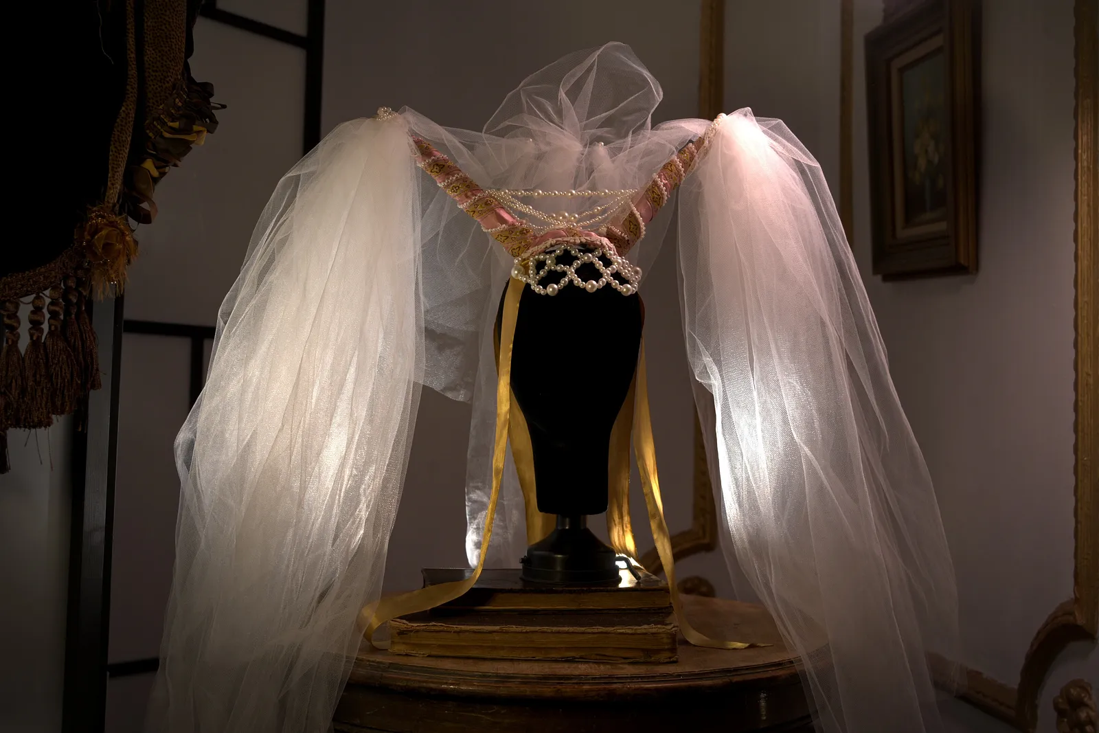Velata: tocado nupcial de perlas con velo amplio de tul, de aire ceremonial medieval.