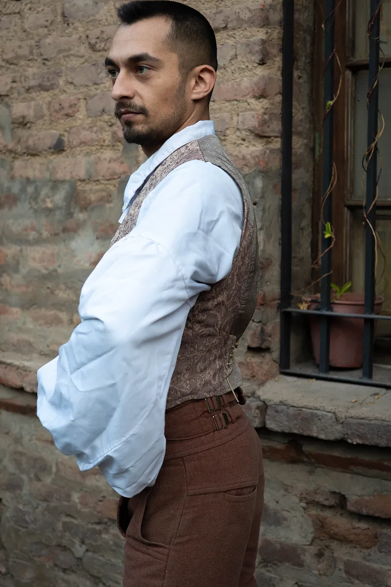 Thomas (chaleco) visto de perfil sobre camisa blanca, mostrando la espalda ajustada y la estructura que aporta al torso.