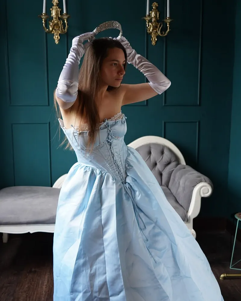 Dos mujeres con vestuario histórico vistas desde lo alto de una escalera