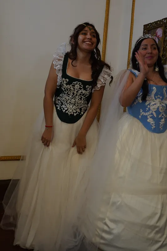 Dos modelos con vestidos de fantasía; a la izquierda, Annie con corpiño verde bordado, vuelos de encaje en los hombros y falda blanca de tul.