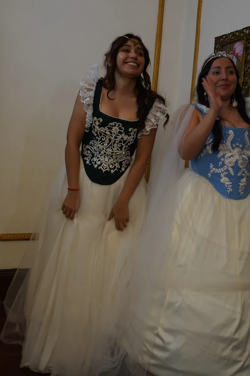 Dos modelos con vestidos de fantasía; a la izquierda, Annie con corpiño verde bordado, vuelos de encaje en los hombros y falda blanca de tul.
