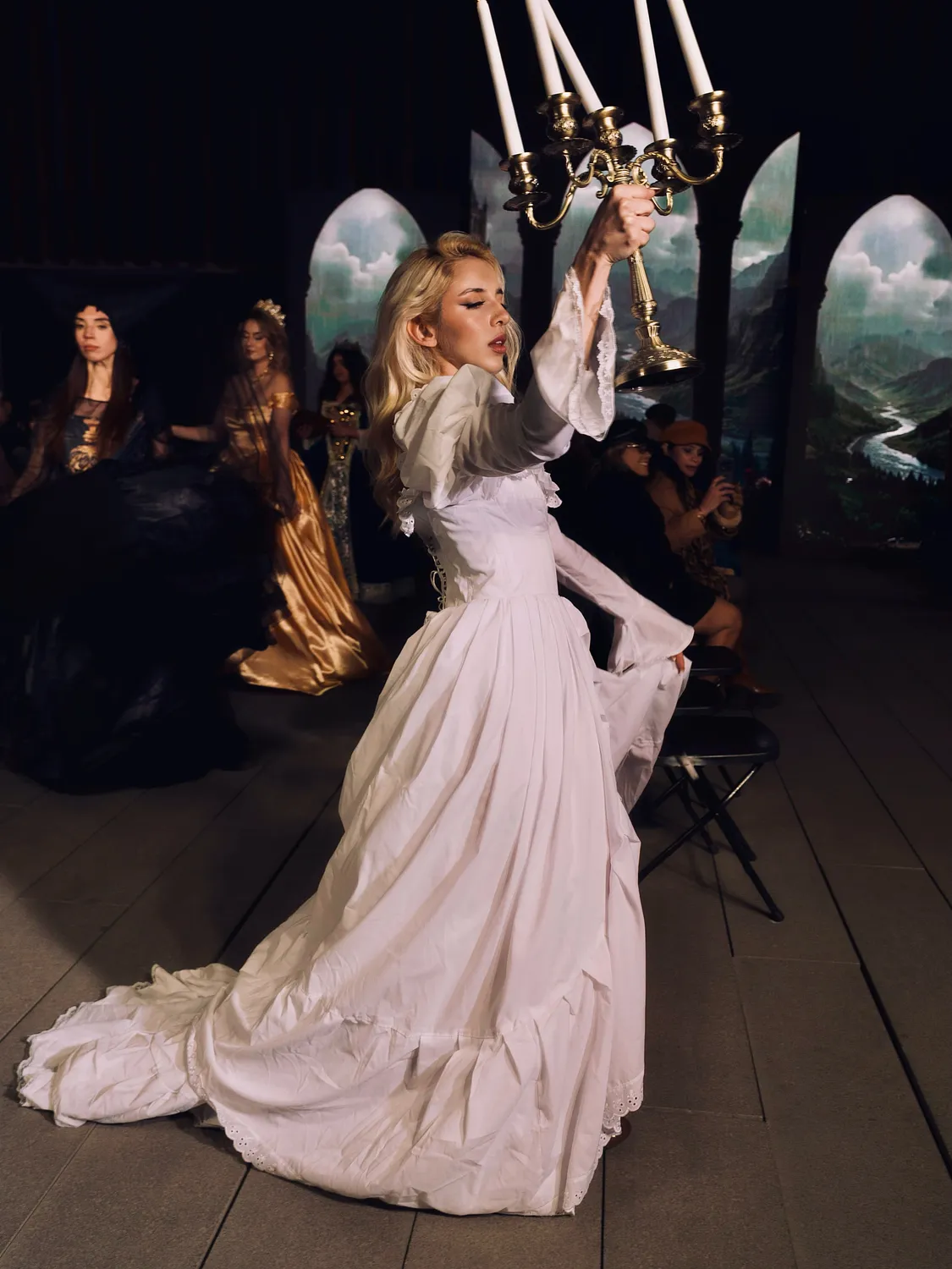 Intérprete con vestido histórico blanco en un escenario teatral